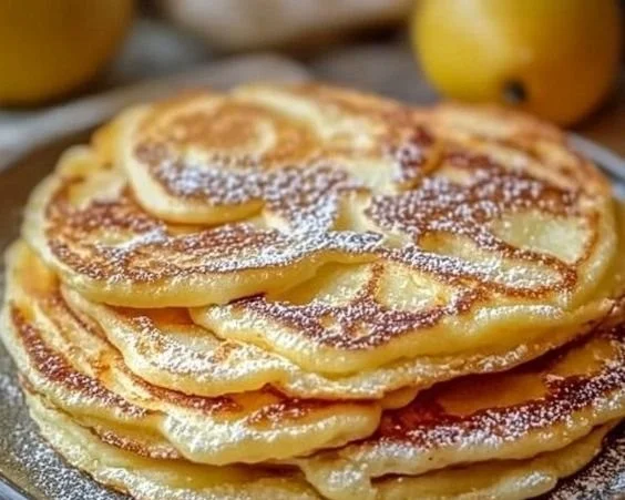 Leckere Apfel-Joghurt-Pfannkuchen auf einem Teller angerichtet