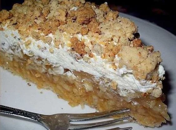 Frischer Apfelkuchen mit Äpfeln und Zimt auf einem rustikalen Tisch