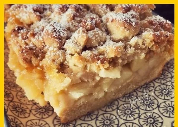Apfelkuchen mit Streuseln auf einem Blech, frisch gebacken und appetitlich angerichtet.