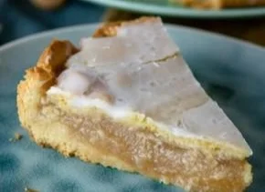 Gedeckter Apfelkuchen mit Zimt-Apfelmus auf einem schönen Teller serviert