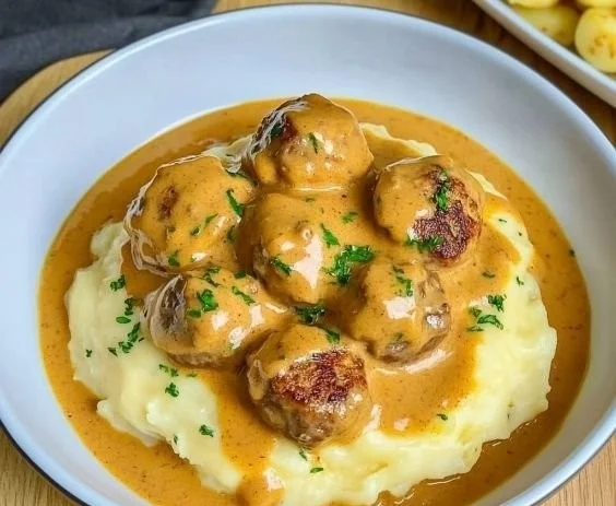Hackbällchen mit cremiger Sauce und Kartoffelpüree auf einem Teller
