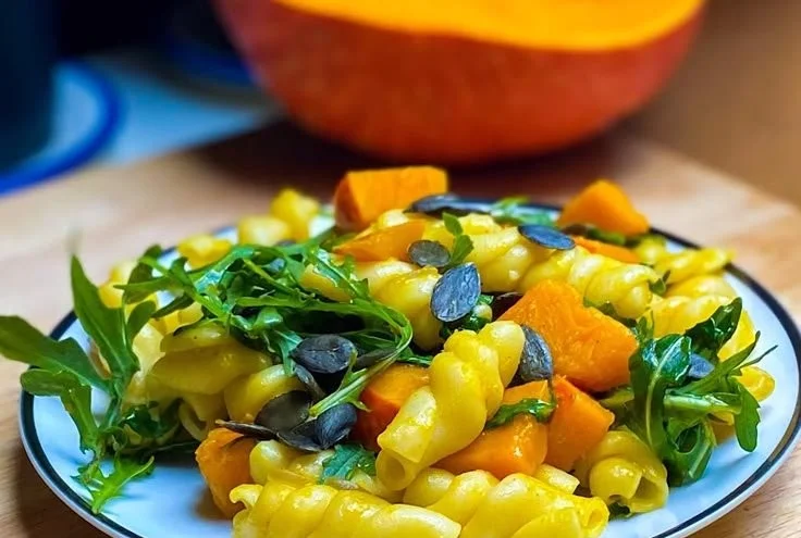 Kürbis-Pasta mit Rucola auf einem Teller angerichtet