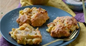 Saftige Apfel-Zimt Taler auf einem Teller mit Zimtsticks und frischen Äpfeln