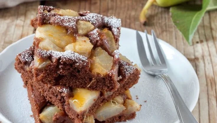 Schoko-Birnen-Kuchen auf einem Teller präsentiert, schokoladig und saftig.