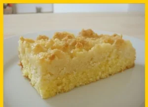 Streuselkuchen mit Sahneguss auf einem Teller serviert